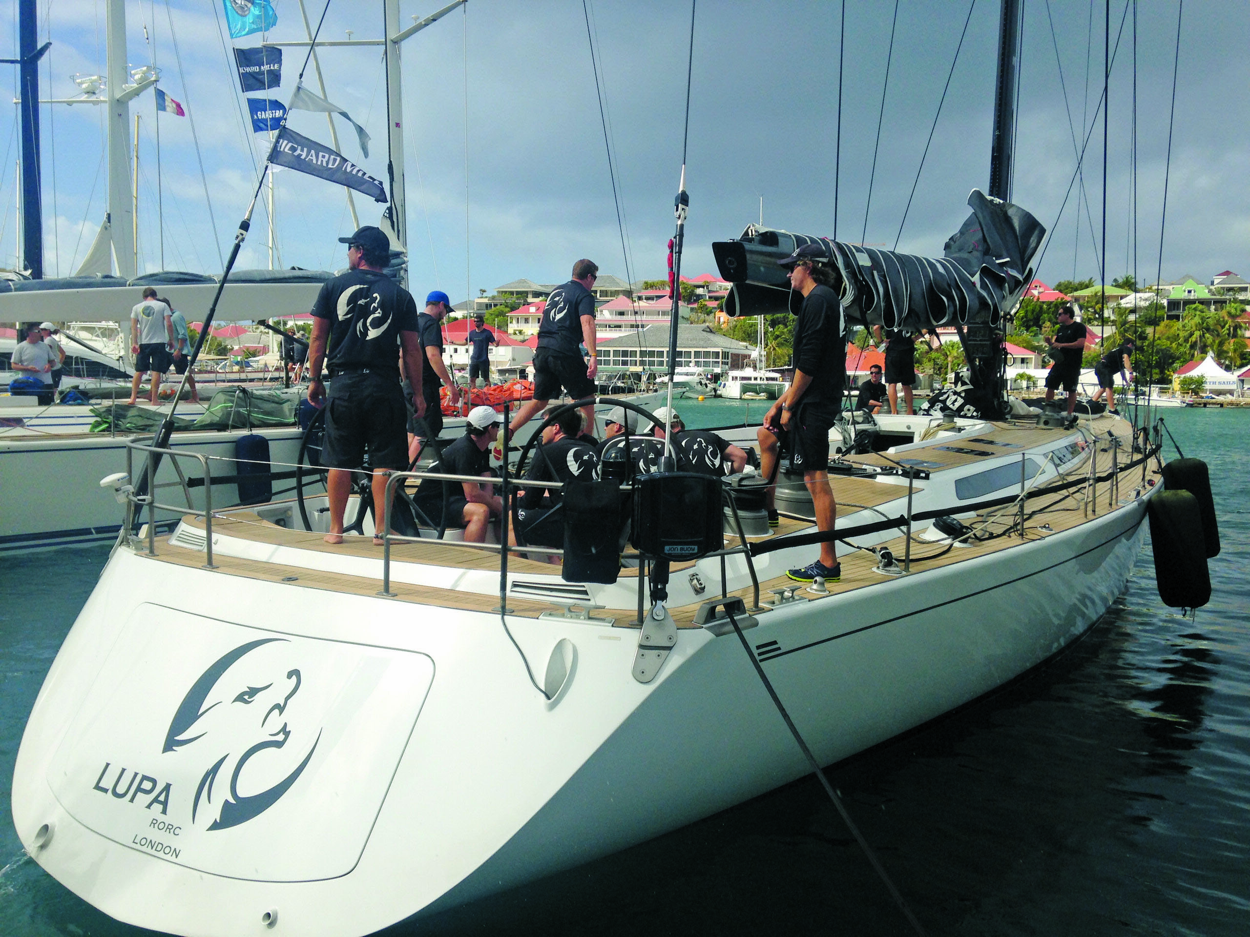 Back of Lupa at anchor; a few people are sitting and standing on board